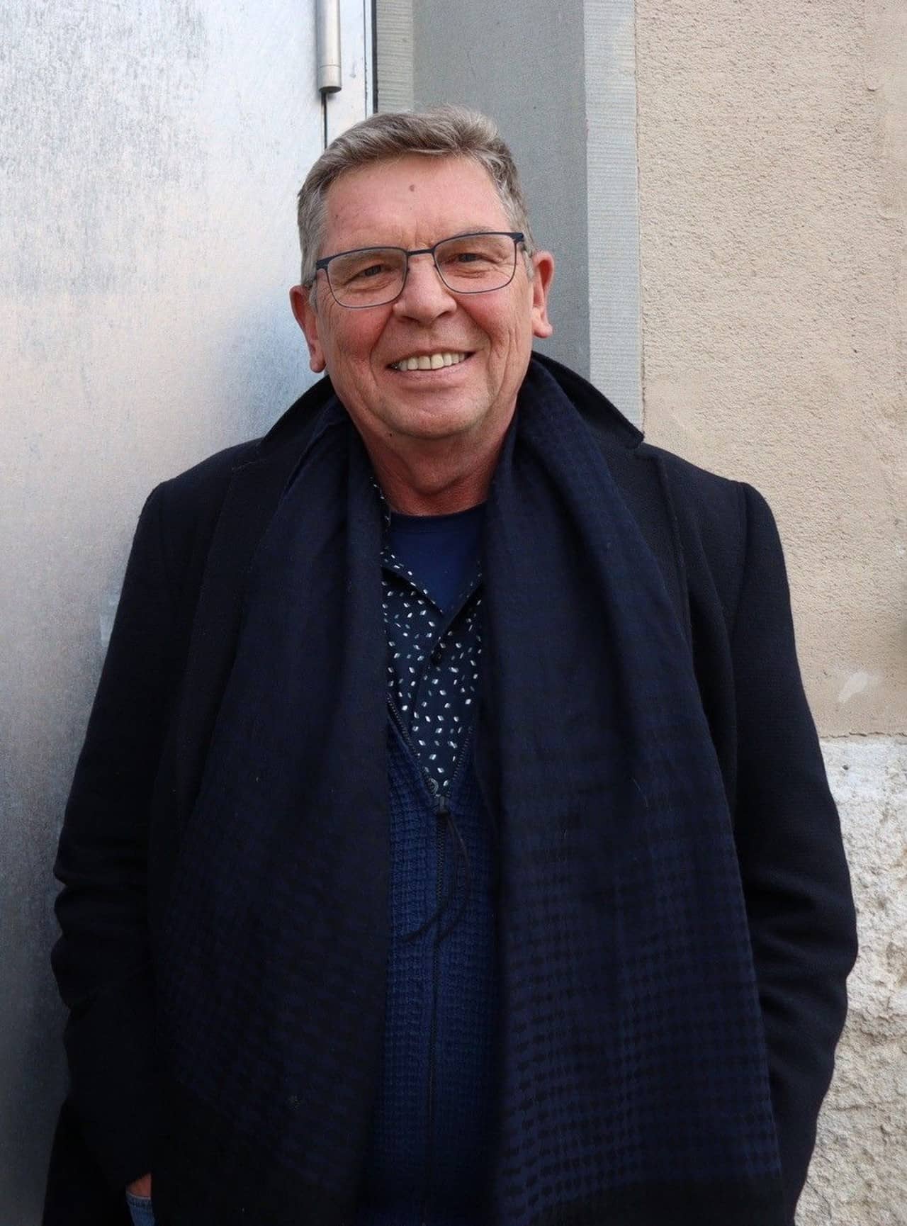 Mann mit Namen Peter-Jakob Kelting, gekleidet mit Mantel und Brille