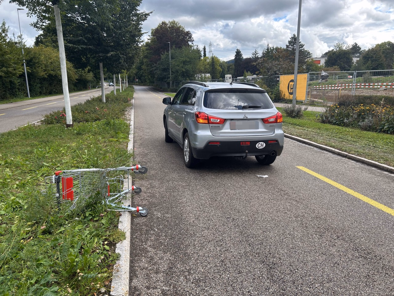 Personenwagen auf Strasse mit Einkaufswagen.