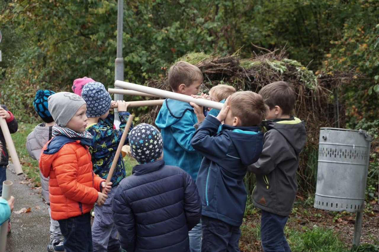 Schülerinnen und Schüler schauen durch Kartonrohre