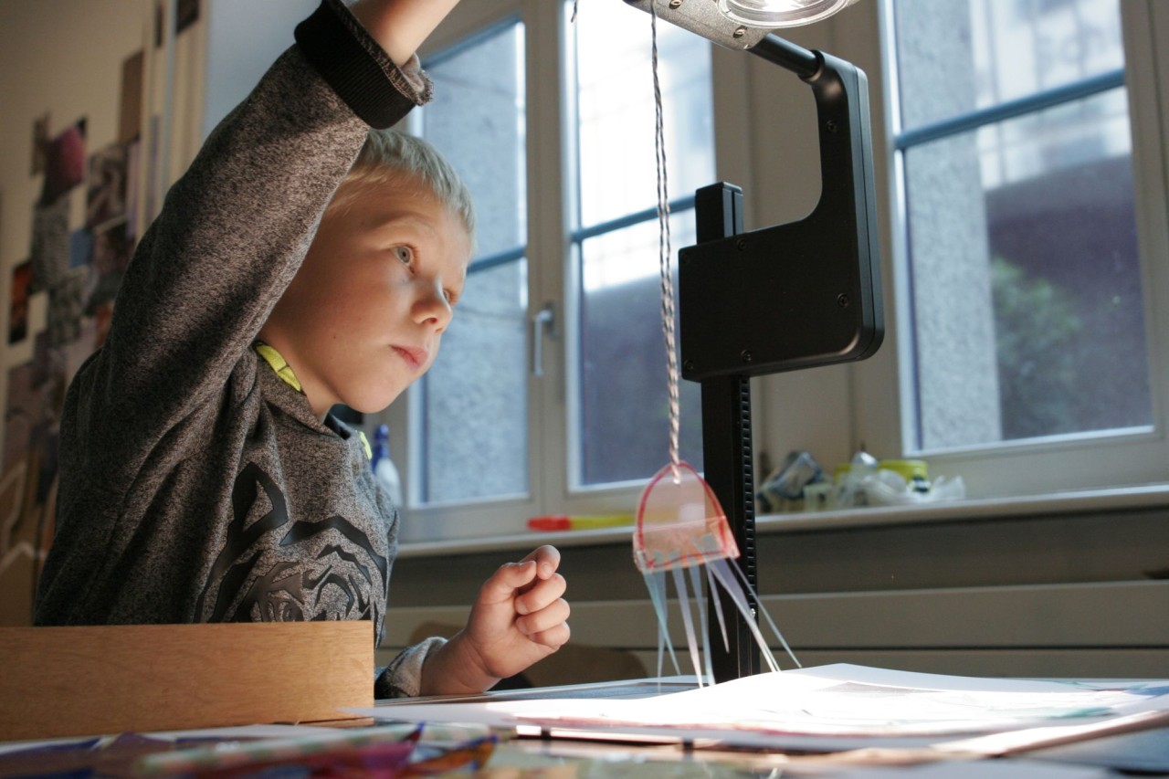 Ein Schüler experimentiert mit Faden und Lampe