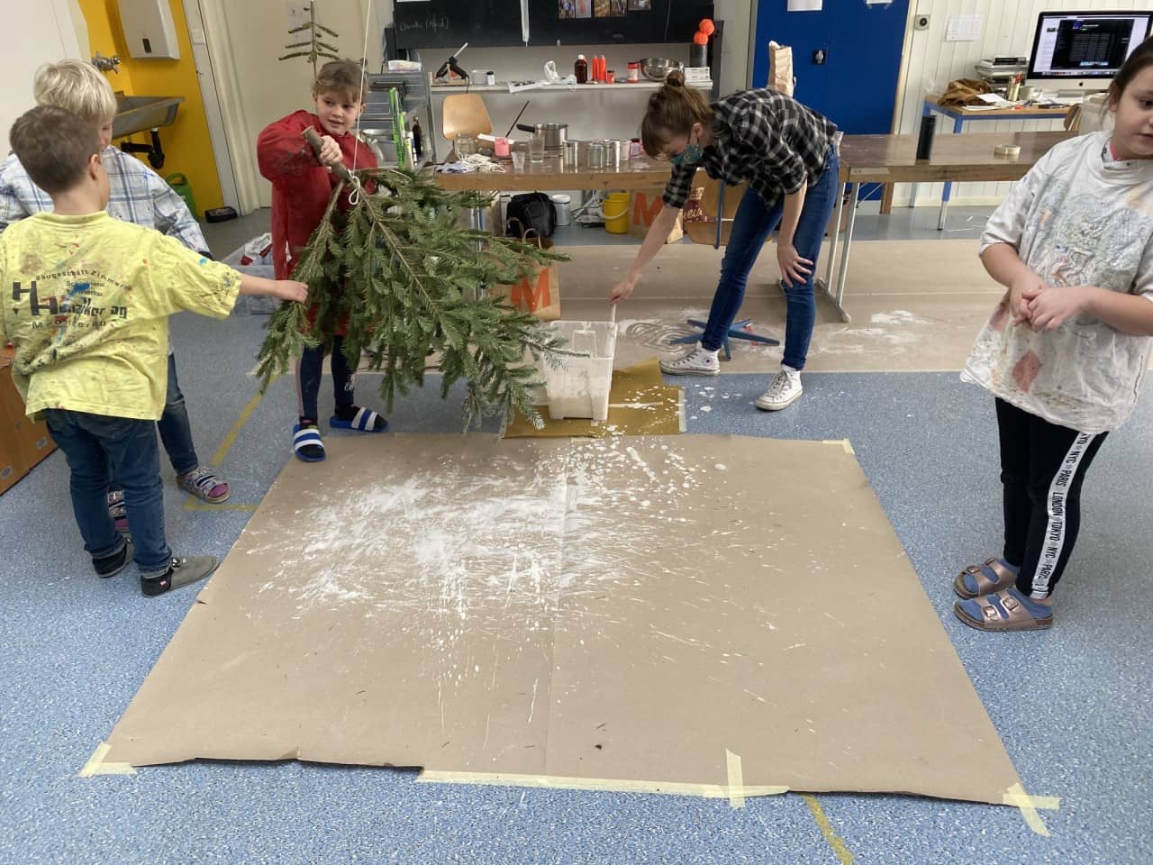 Kinder arbeiten mit Karton am Boden