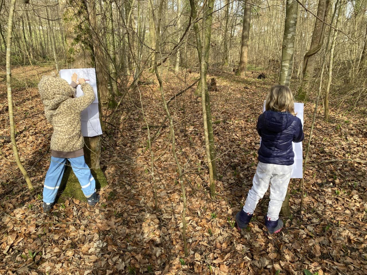 zwei Kinder zeichnen im Wald