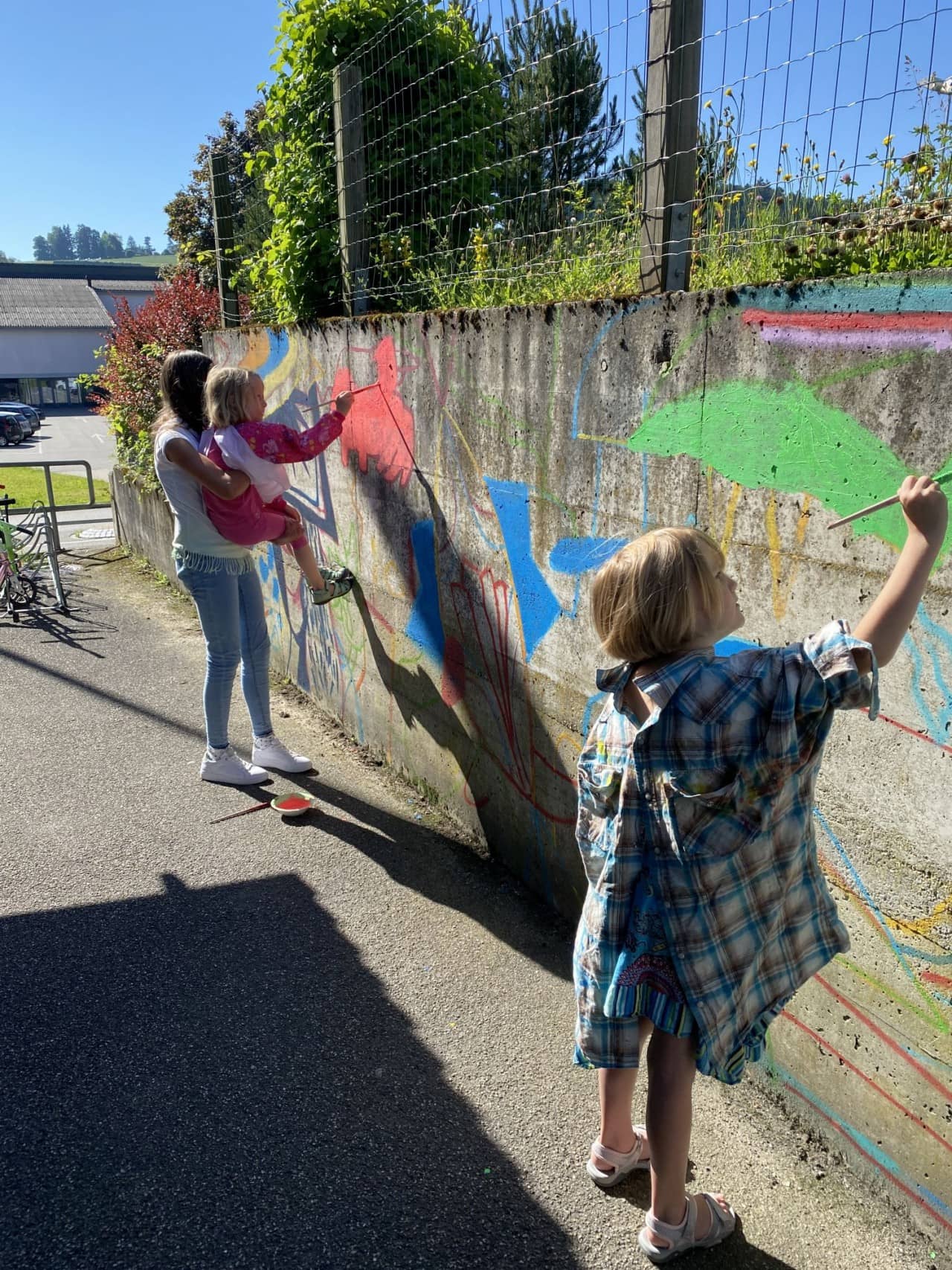 Kinder bemalen eine Mauer