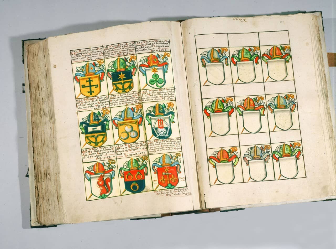 Aufgeschlagener Band mit auf linker Seite beschrifteten farbigen Wappen und auf rechter Seite vorgezeichnete unbeschriftete Wappenvorlagen.