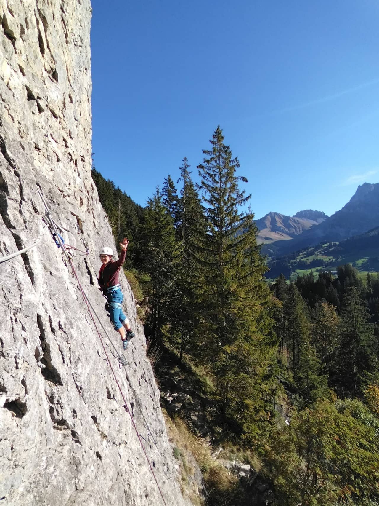 Eine junge Dame klettert die Outdoor-Kletterwand hoch.