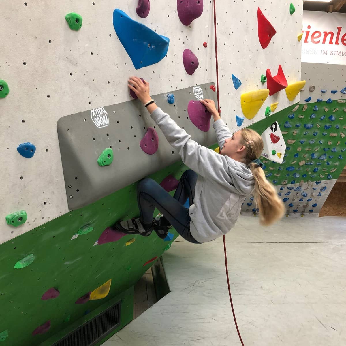 Ein Mädchen ist in der Halle am Bouldern.