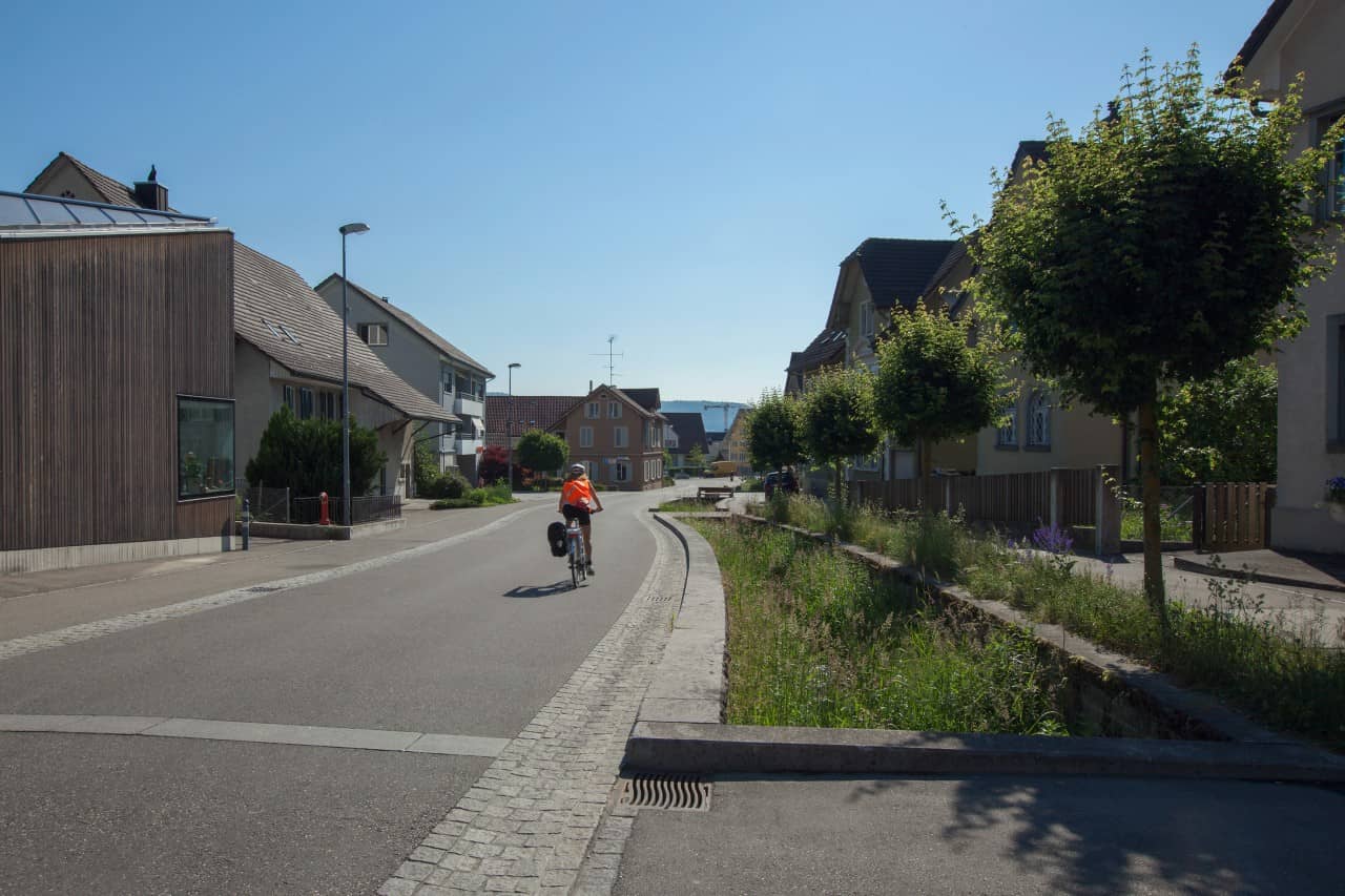 Eine Velofahrerin fährt auf der neu gestalteten Dorfstrasse in Spreitenbach.