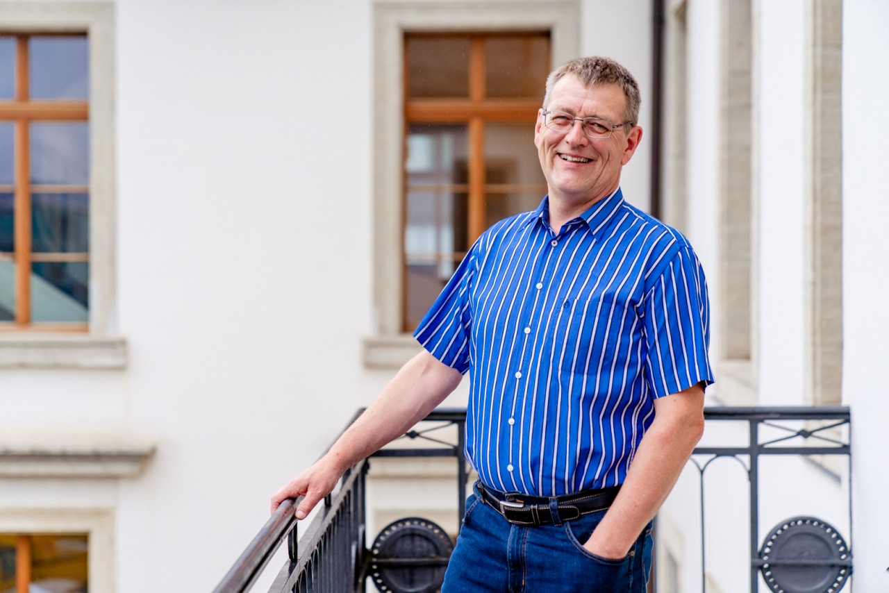 Mann steht auf einem Balkon